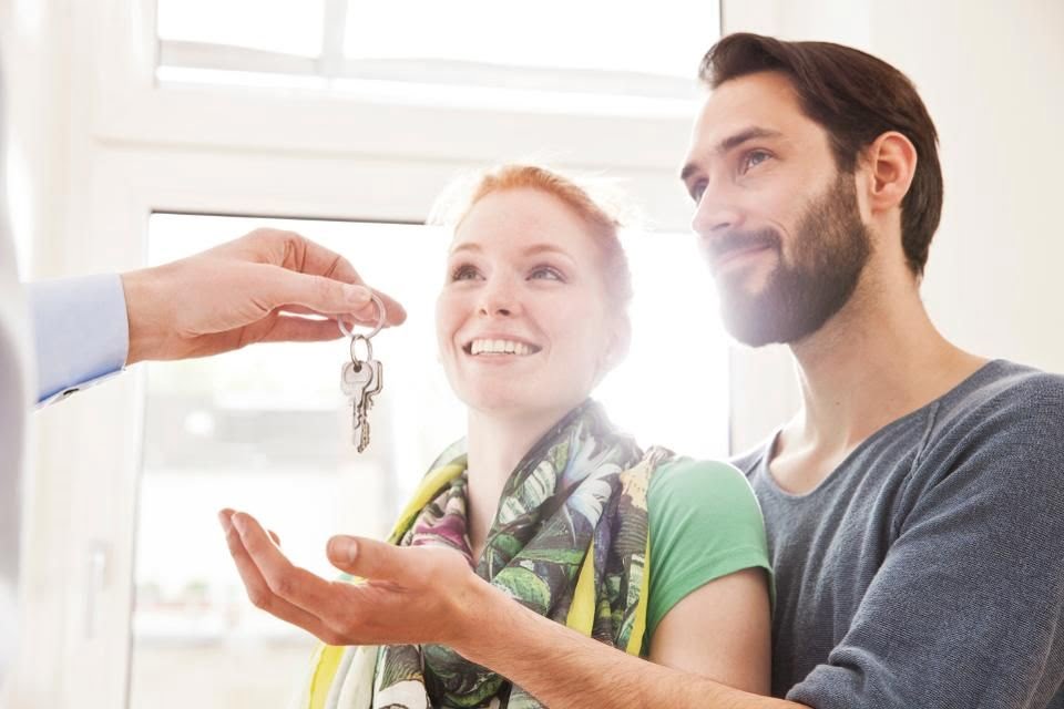 Image of couple picking up key from broker
